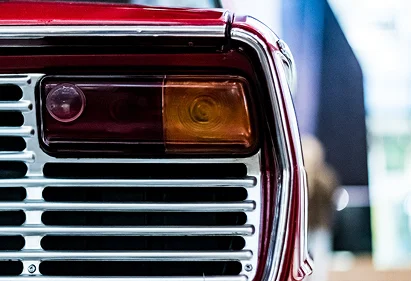 Close-up of a classic car's chrome grille and taillight