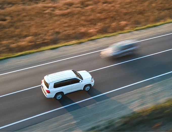 White SUV driving on the highway, protected by an extended warranty
